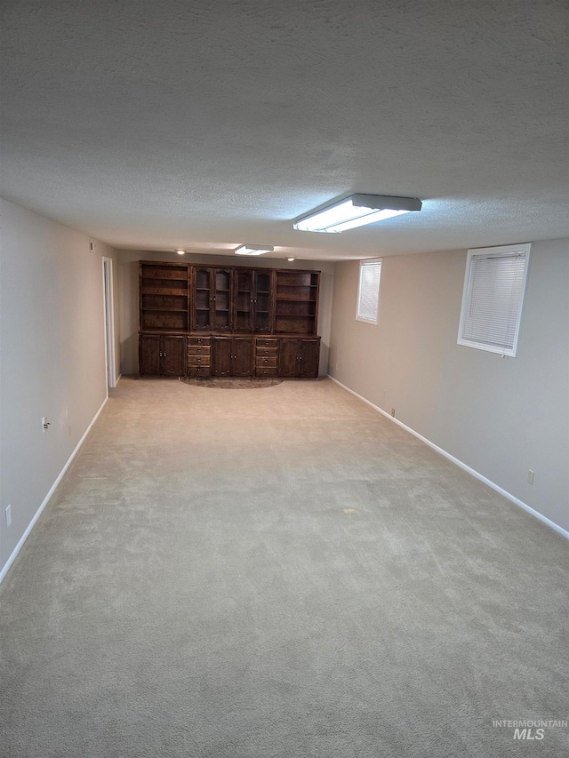 basement with light colored carpet and a textured ceiling