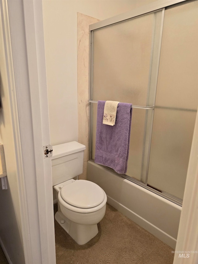 bathroom with shower / bath combination with glass door and toilet