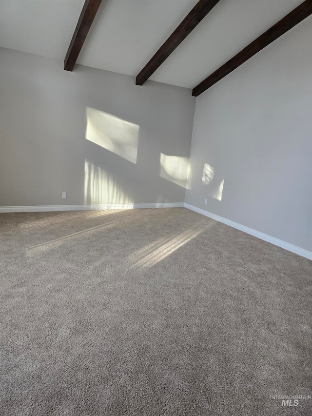 carpeted empty room featuring beam ceiling