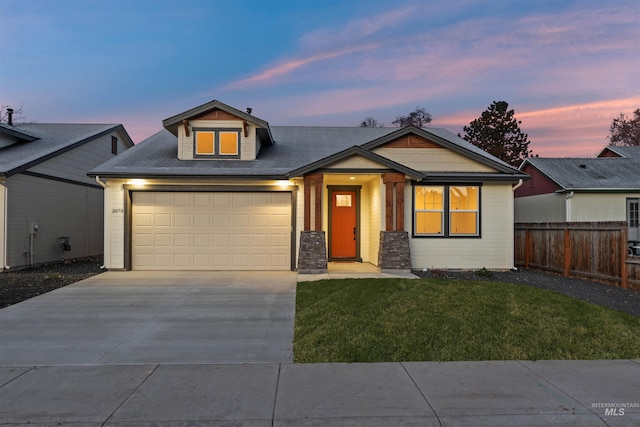 view of front of home with a garage and a lawn