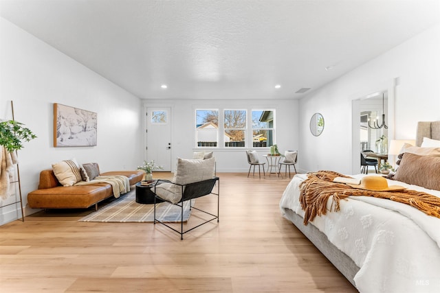 bedroom with a textured ceiling and light wood-type flooring