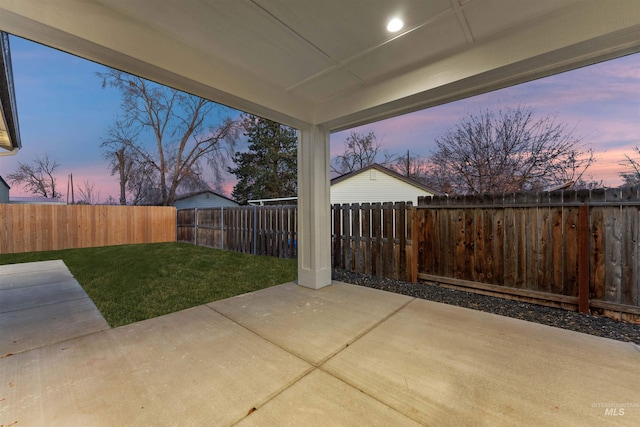 patio terrace at dusk featuring a yard