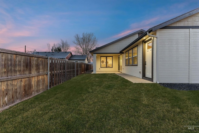 yard at dusk featuring a patio area