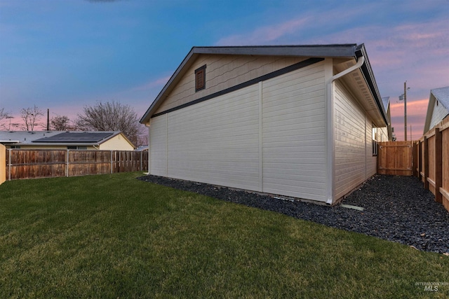 property exterior at dusk with a lawn