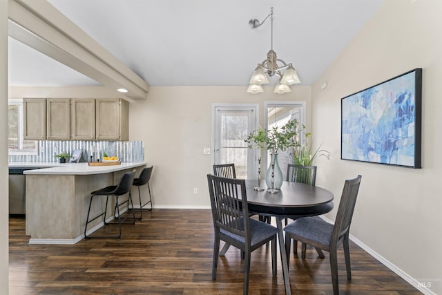 dining room featuring a chandelier, lofted ceiling, dark wood-style flooring, and baseboards