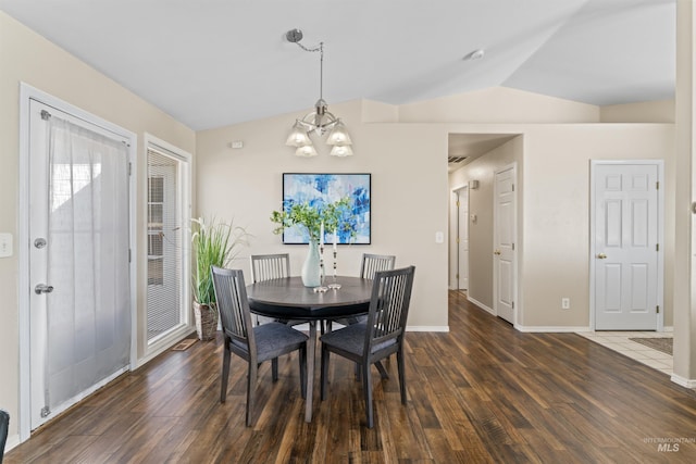 dining room featuring vaulted ceiling, a chandelier, wood finished floors, and baseboards