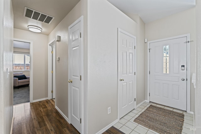 entrance foyer featuring baseboards, visible vents, and wood finished floors