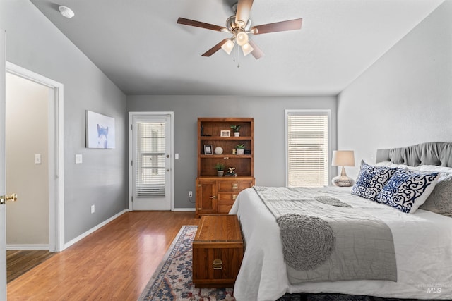 bedroom with a ceiling fan, baseboards, and wood finished floors