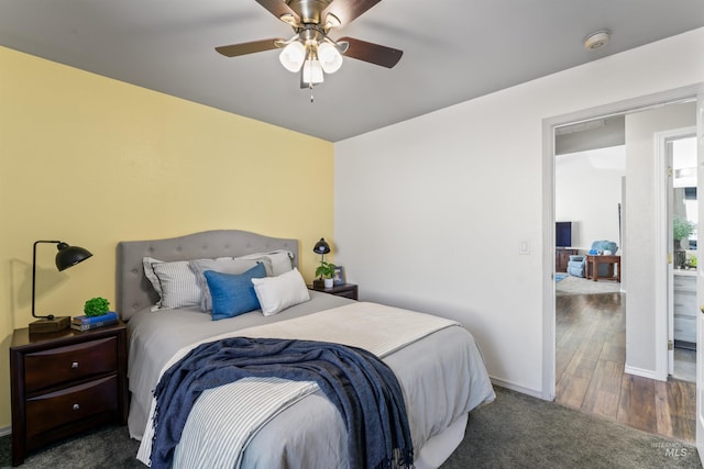 carpeted bedroom with a ceiling fan, baseboards, and wood finished floors