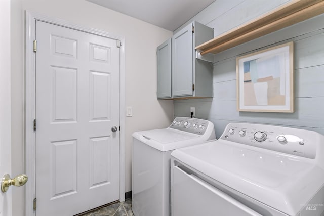 clothes washing area with washing machine and clothes dryer and cabinet space