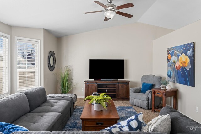 carpeted living room featuring a ceiling fan, vaulted ceiling, and baseboards