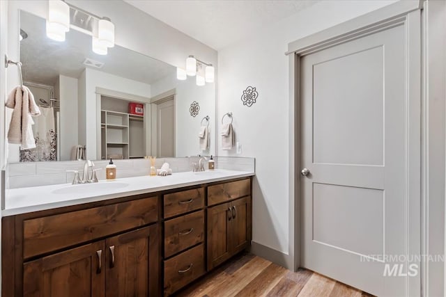 302 Broken Crk, Mccall, ID 83638 - full bathroom with wood finished floors, double vanity, decorative backsplash, and a spacious closet