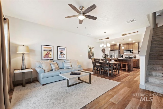 302 Broken Crk, Mccall, ID 83638 - living area with stairway, light wood finished floors, a ceiling fan, and a chandelier