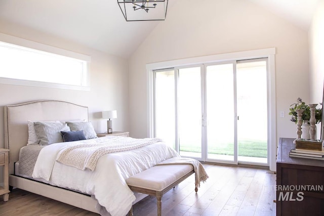 bedroom with high vaulted ceiling, access to outside, and light wood-type flooring