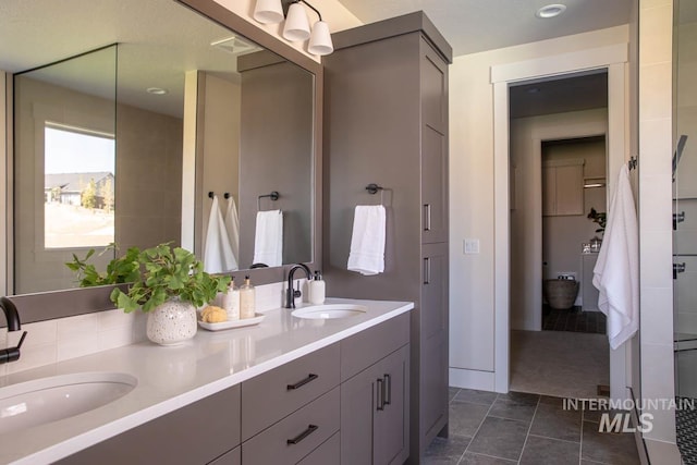 full bathroom featuring double vanity and a sink