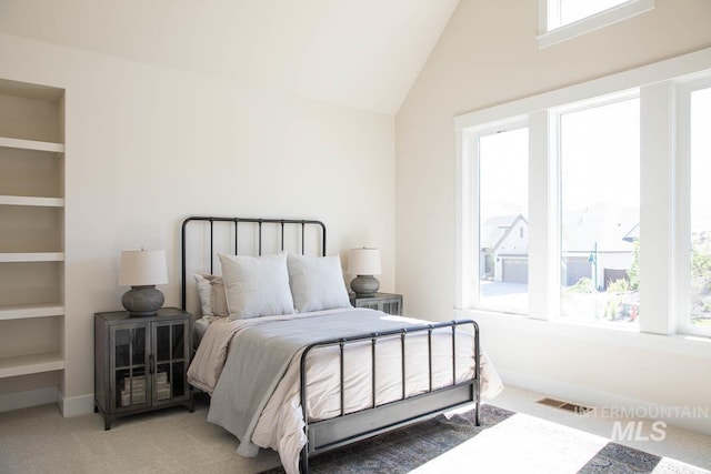 carpeted bedroom featuring visible vents and vaulted ceiling