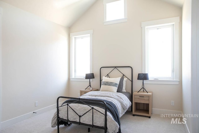 bedroom with baseboards, high vaulted ceiling, and carpet
