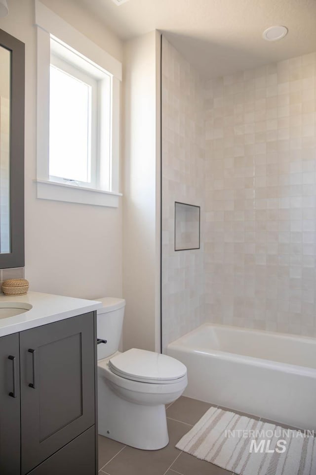 bathroom featuring toilet, vanity, washtub / shower combination, and tile patterned floors