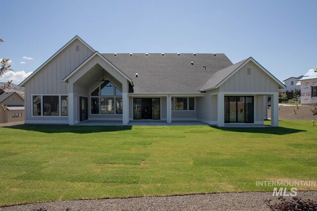 11179 N Elk Ridge Way, Boise, ID 83714 - rear view of house with board and batten siding, a patio, and a lawn