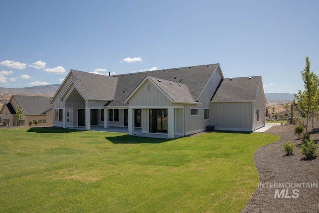 11179 N Elk Ridge Way, Boise, ID 83714 - rear view of property featuring a shingled roof, board and batten siding, a lawn, a mountain view, and a patio