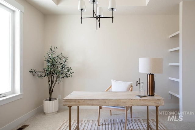 office area featuring a chandelier, baseboards, and carpet floors