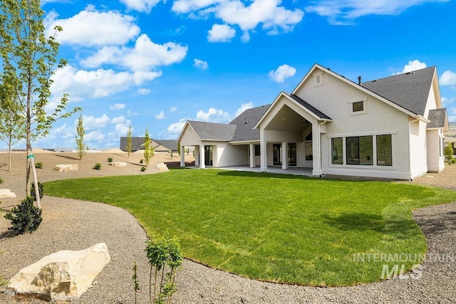 11179 N Elk Ridge Way, Boise, ID 83714 - back of property featuring roof with shingles, a patio area, stucco siding, and a yard