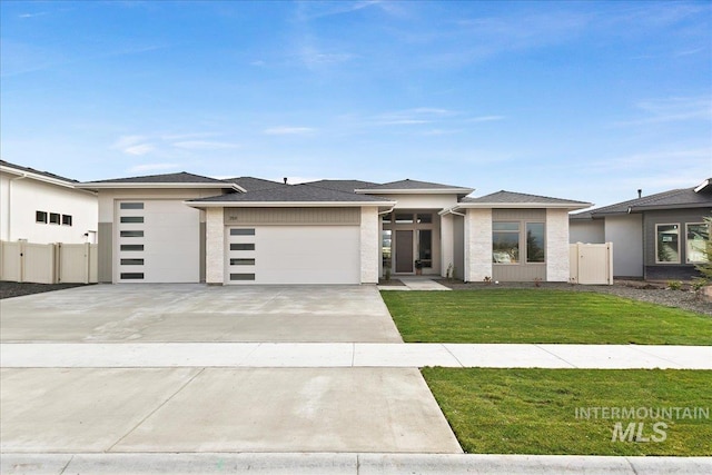 prairie-style home with a front lawn and a garage