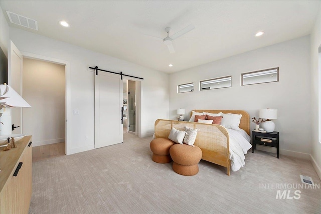 bedroom featuring a barn door and ceiling fan