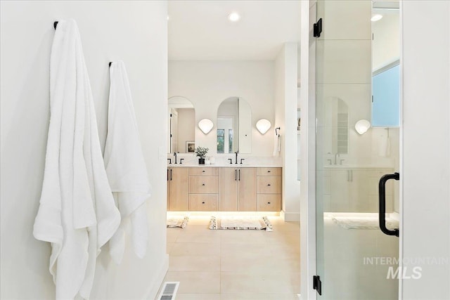 bathroom featuring tile patterned floors, vanity, and a shower with shower door