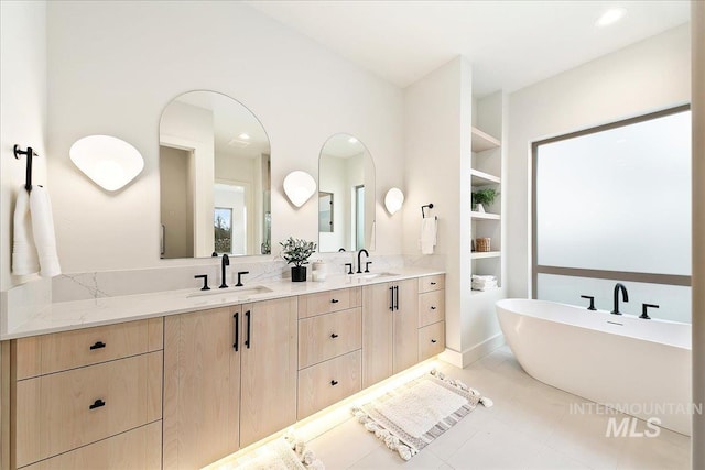 bathroom featuring built in shelves, vanity, tile patterned floors, and a bathtub