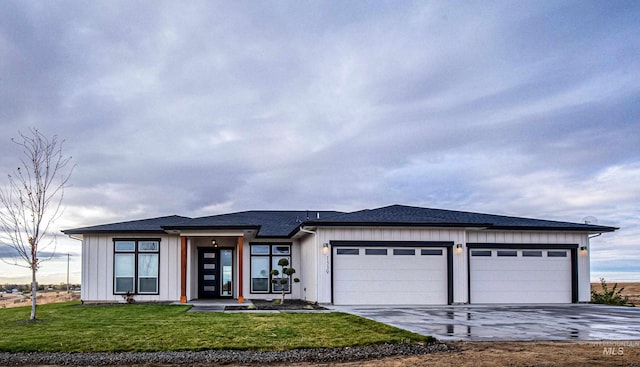 prairie-style home featuring a front yard and a garage