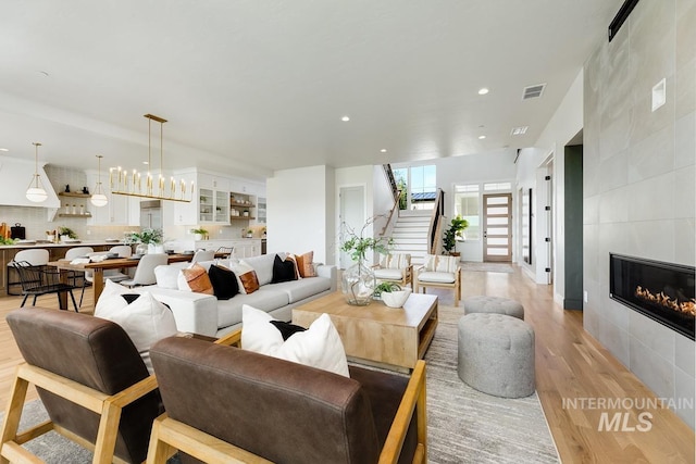 5935 E Marmount Ct, Boise, ID 83716 - living area with light wood-type flooring, stairs, recessed lighting, and a tiled fireplace