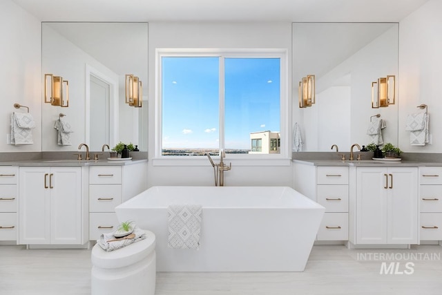 5935 E Marmount Ct, Boise, ID 83716 - bathroom with two vanities, a freestanding tub, and wood finished floors