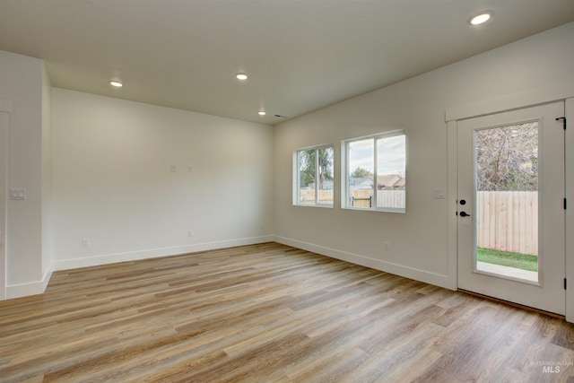 unfurnished room with recessed lighting, baseboards, and light wood finished floors