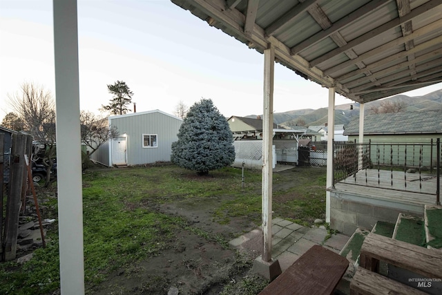 view of patio with a mountain view and a storage shed