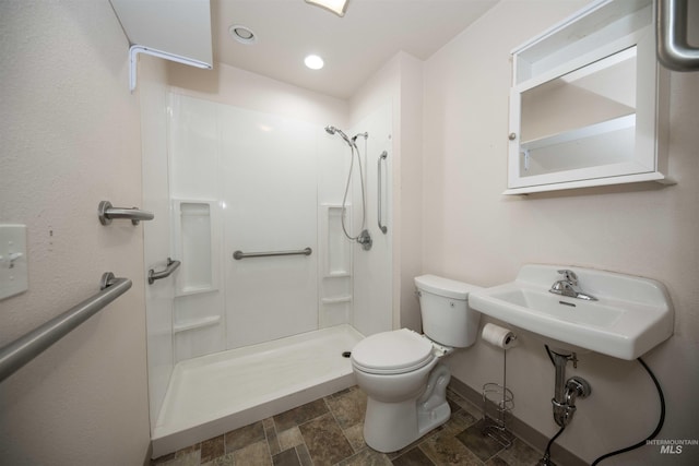 bathroom featuring toilet, a shower, and sink