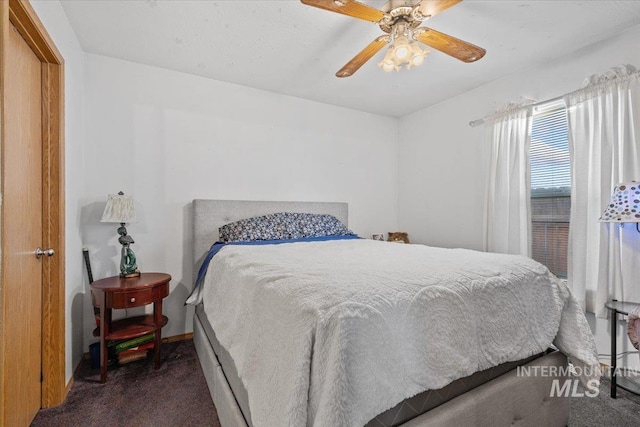 bedroom featuring ceiling fan and dark colored carpet