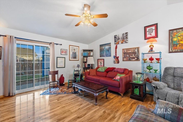 living room with ceiling fan, light hardwood / wood-style flooring, and lofted ceiling