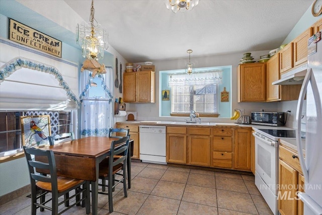 kitchen featuring a notable chandelier, decorative light fixtures, white appliances, and sink