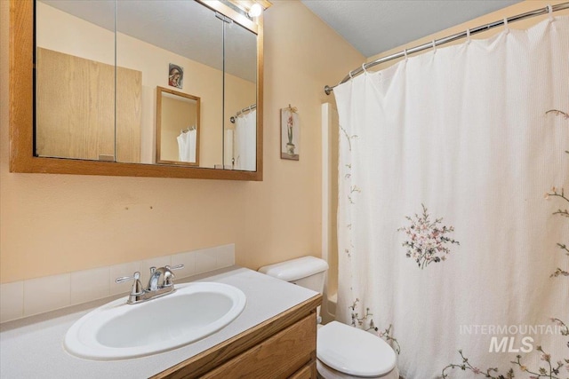 bathroom featuring walk in shower, vanity, and toilet