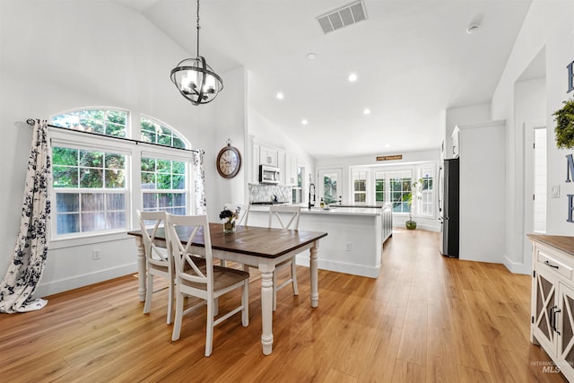 3832 W Aspen Creek Ct, Meridian, ID 83642 - dining space featuring light wood-type flooring, a chandelier, high vaulted ceiling, baseboards, and recessed lighting