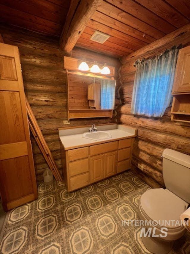 bathroom with toilet, wooden ceiling, vanity, beamed ceiling, and tile patterned flooring