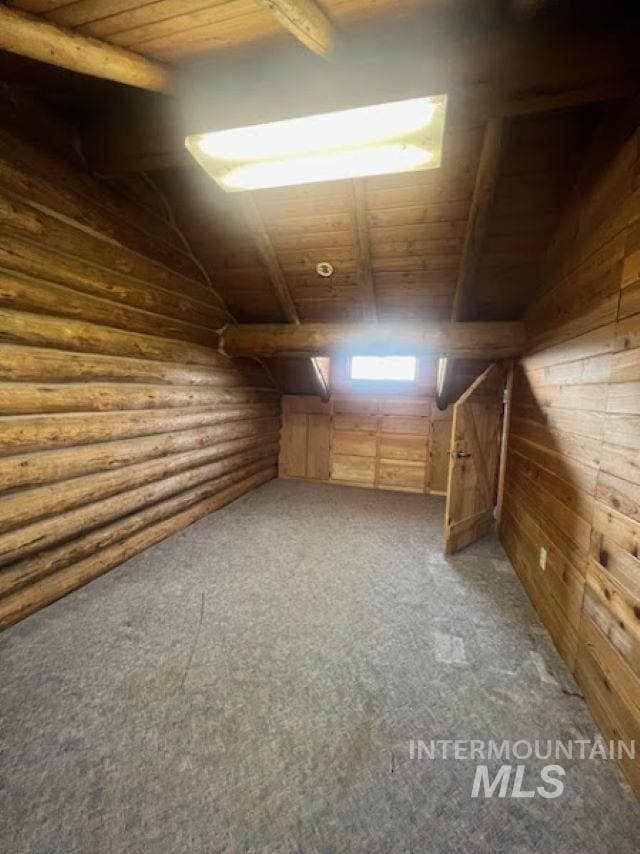 bonus room with carpet, vaulted ceiling with beams, log walls, and wood ceiling