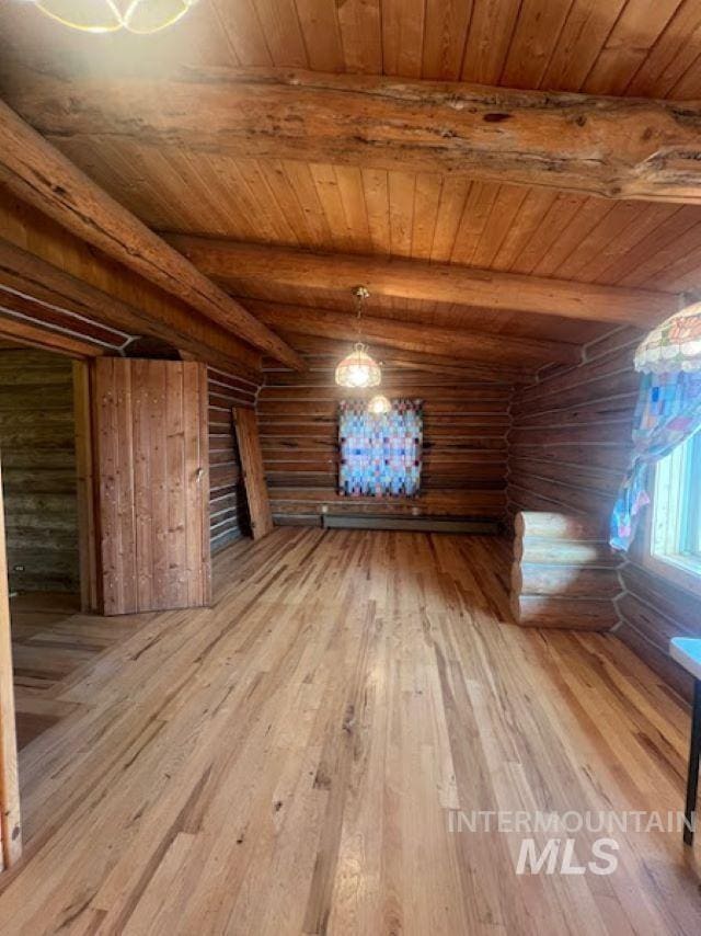 additional living space with log walls, wood-type flooring, wooden ceiling, and beam ceiling