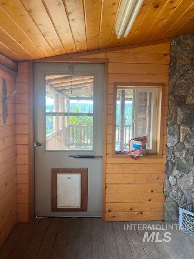 entryway with wood ceiling, dark wood-type flooring, and wooden walls