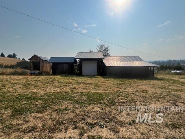 exterior space featuring a rural view, a yard, and a garage