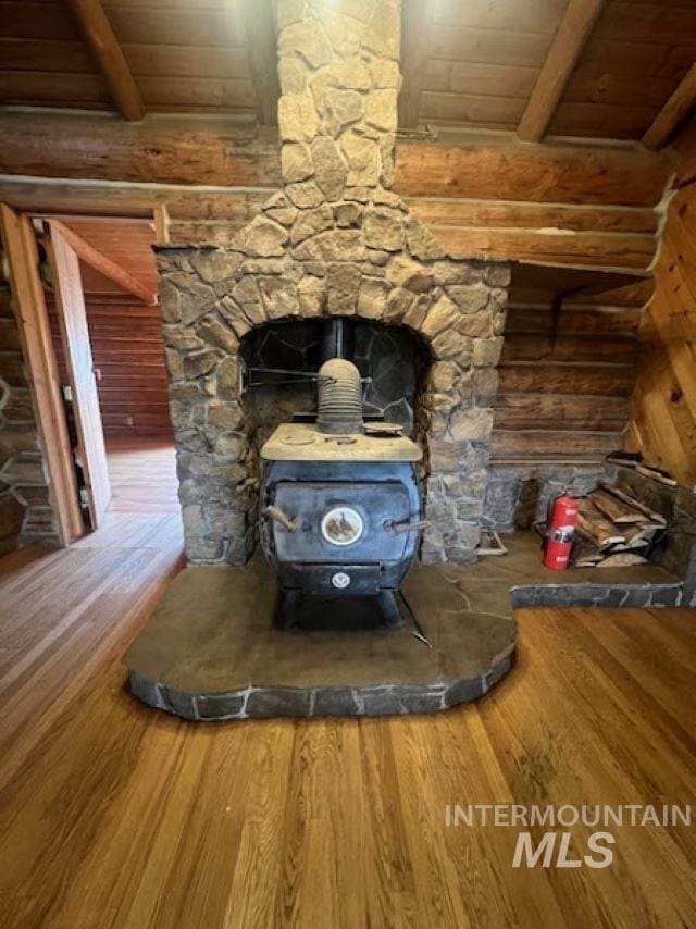 details with wood ceiling, hardwood / wood-style flooring, and a wood stove