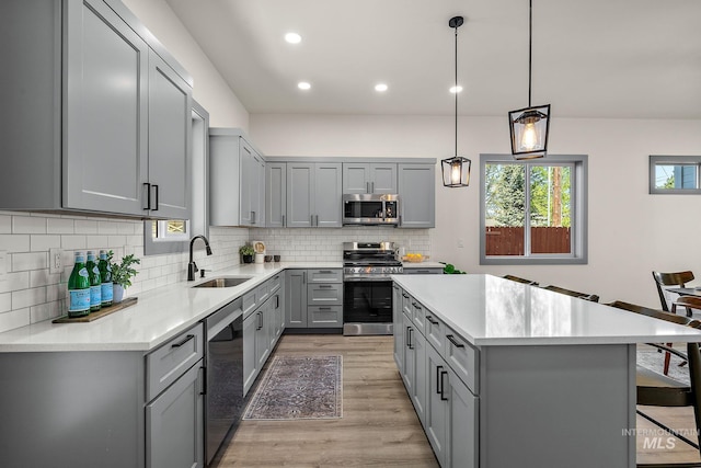 6825 W Ustick, Boise, ID 83704 - kitchen featuring gray cabinets, a kitchen island, light wood-type flooring, a sink, and stainless steel appliances