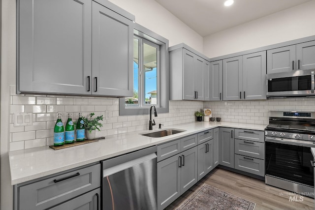 6825 W Ustick, Boise, ID 83704 - kitchen featuring a sink, gray cabinets, appliances with stainless steel finishes, and wood finished floors
