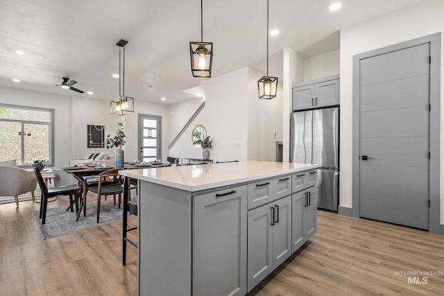 6825 W Ustick, Boise, ID 83704 - kitchen featuring a center island, gray cabinets, freestanding refrigerator, and light wood-type flooring
